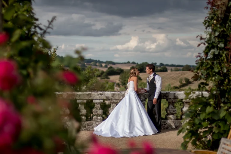 Couple en tenue de mariage sur mesure : robe de mariée corsetée et gilet corseté pour homme, création artisanale réalisée par l’atelier Marjorie G. CREATION en Vendée.